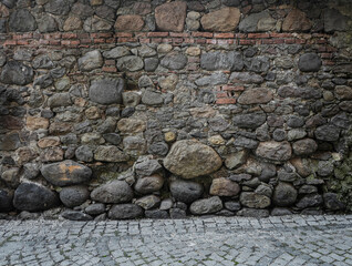 Abstract old historical background with uneven round pebble stones. Wall round stone rock texture or background. cobblestone road floor.