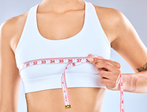 Girl, measure and tape on boobs in studio for chest fitting or underbust measurement, growth and size for fitness or postpartum changes. Woman, isolated and white background with tracking breasts.