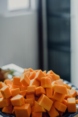 Sweet orange pumpkin cut into cubes in plate, closeup photo, Pumpkin cubes on a plate, captured in raw form, ideal for culinary inspiration