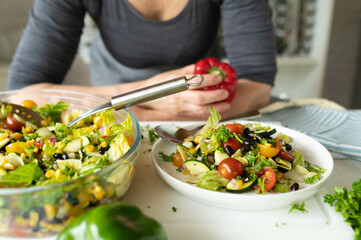 Woman with a fresh prepared healthy mexican salad in the kitchen