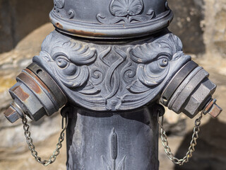Vintage cast iron fire hydrant adorned with ornate floral designs