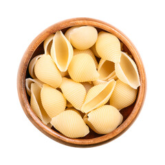 Conchiglie rigate, shell shaped and furrowed Italian pasta in a wooden bowl. Uncooked durum wheat semolina pasta. Close-up, from above, isolated on white background, macro food photo.