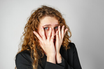 Young Woman Covering Face With Hands in Studio