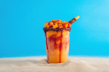 Mangonada, typical mexican mango smoothie on summer background.