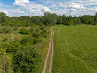 Country road leading through a meadow, view from the top