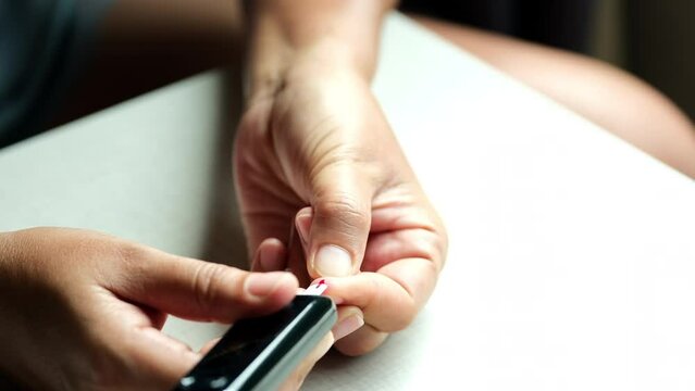 Woman's hands checking diabetes and hyperglycemia with digital blood sugar meter. Healthcare and medical concept