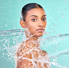 Indian woman, portrait and water splash for skin care, hygiene and beauty or dermatology in studio....