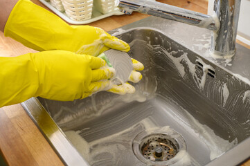 Mycie zlewu kuchennego w gumowych rękawicach 