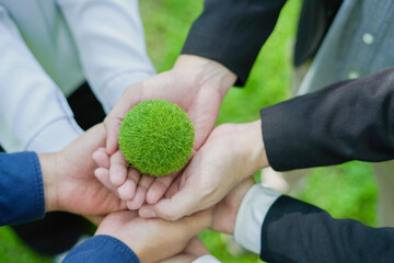 Business team embraces the earth with hands united, promoting  green concept for nature...