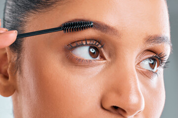 Beauty, zoom and woman with mascara brush in studio for apply cosmetics, makeup or lashes on white...