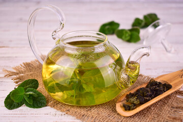 Mint tea in a transparent glass teapot.
