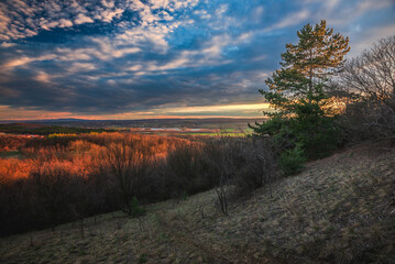 Obraz premium Winter landscape in the sunset. View to Sokoro hills and far distance Bakony Mountain from Pannonhalma, Hungary