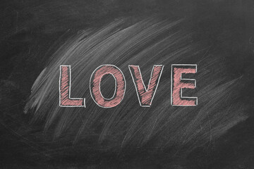 The word LOVE is artfully drawn on a blackboard with white and pink chalk. The chalkboard features large, stylized letters.
