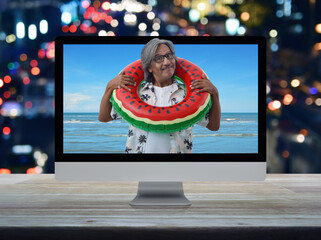 Happy senior traveler asian man wearing casual shirt and glasses in watermelon inflatable ring with...