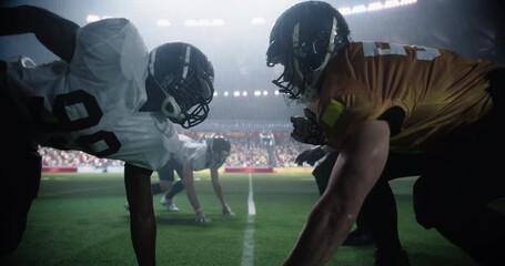 Two Diverse American Football Teams Play a Dynamic Match in Soaking Wet Weather in Front of a Stadium Filled with Spectators. Players Making a Stand-Off Before Quarterback Passes the Ball - Powered by Adobe
