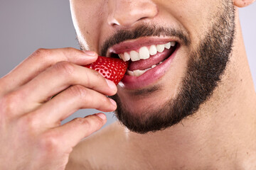 Health, mouth and strawberry with person eating fruit closeup in studio on gray background. Diet,...