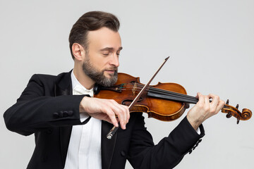 Elegant man violinist on stage performing concert