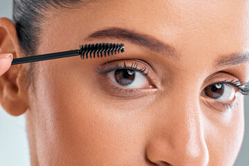 Portrait of woman, beauty and closeup with mascara brush in studio for makeup, cosmetics or curling...