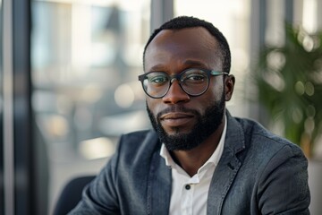 Confident young businessman wearing glasses in a modern office environment