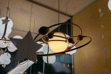 Matte lamp in the shape of a planet and satellites.