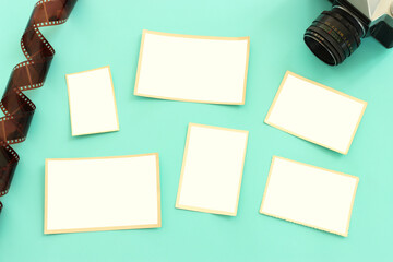 top view of blank photo frames over pastel blue background.