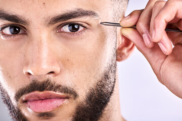 Man, portrait and tweezers for eyebrow on face in studio, selfcare and personal grooming. Model,...
