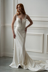 Fototapeta premium Beautiful young woman bride in fashion wedding dress in white interior