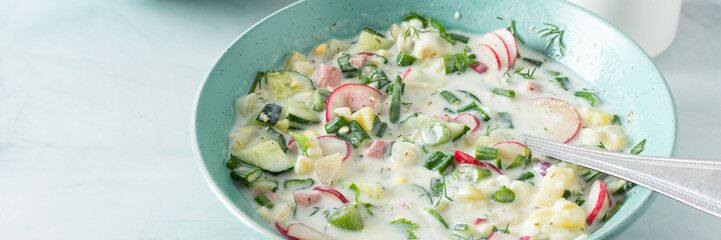Cold summer soup Okroshka banner, soup with vegetables and sausage, eggs and fresh herbs and yogurt, traditional Russian soup