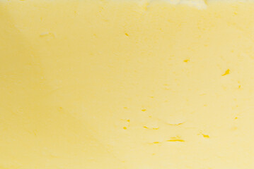Sliced butter texture yellow background. Macro shot.