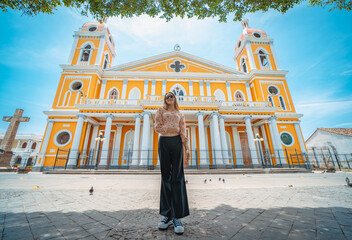 Portrait of a beautiful tourist girl in front of the cathedral in Granada, Nicaragua. Portrait of happy girl in front of a cathedral in a tourist square