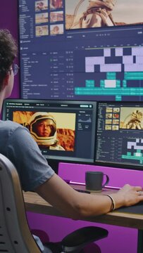 Young editor works at home office, edits sound tracks for video or movie about space mission. Film footage and software interface with tools on PC and big digital screen. Concept of post production.