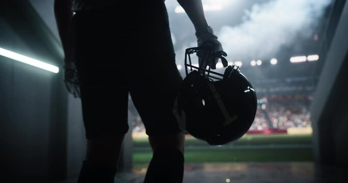 Cinematic Football Walkout: Successful Player Entering a Massive American Football Stadium to the Noise and Cheering of the Anticipating Fans. Epic Close Up Back View of an Anonymous Athlete