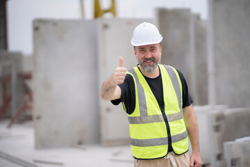 Senior White engineer thumb up at camera with smile at work site. Portrait og engineer wearing white hard hat at manufactuing.