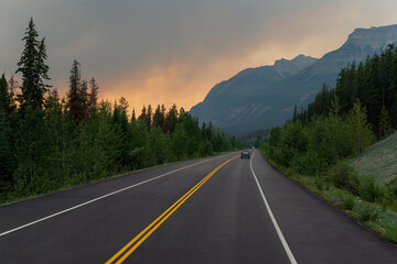 Dramatic landscape with smoke clouds along highway in British Columbia during wildfires, Canada.