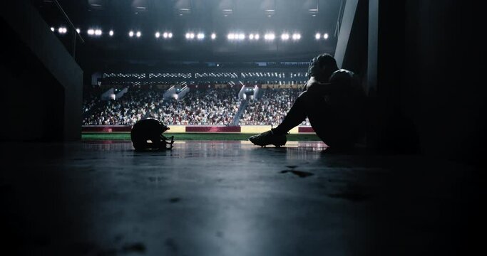 American Football Player Sitting Alone in Stadium Tunnel. Male Athlete Nervous Before a Championship Game. Intense, Emotional Scene with a Footballer Gathering Thoughts and Calming Himself Down