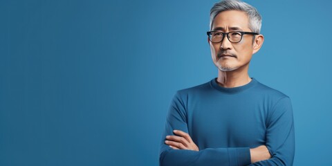 Blue background sad Asian man. Portrait of older mid-aged person beautiful bad mood expression boy Isolated on Background depression anxiety fear burn out health issue problem 