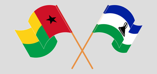 Crossed and waving flags of Guinea-Bissau and Lesotho