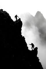 Two people working together to reach the top of a mountain