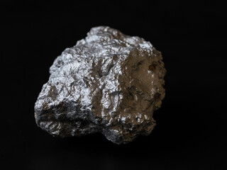 Closeup pure silver nugget from the mine on black background.   Finance and business concept.