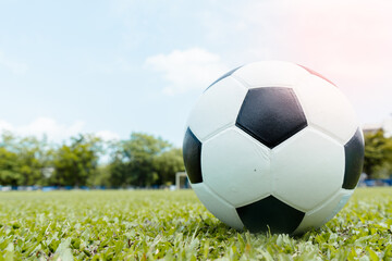 Soccer ball on the grass and football player exercising