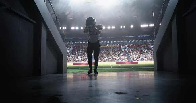 Cinematic Portrait of a Professional Footballer in White Uniform Walking Away From a Stadium in a Tunnel. Best Player is Celebrated by a Full Arena of Sports Fans in a Big Outdoors Stadium