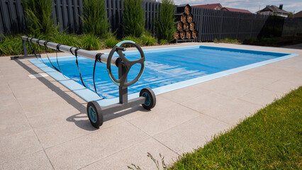 Home outdoor pool covered with film to save chemicals, water and heat preservation