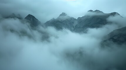 Mountains peek through clouds, creating a mystical, ethereal beauty that captivates beholders.