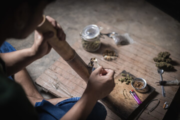 A man prepares marijuana on a cutting board to smoke, person who smokes drugs, drug addict, Drugs...