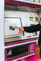 A tourist buys commuter train tickets on purchase screens