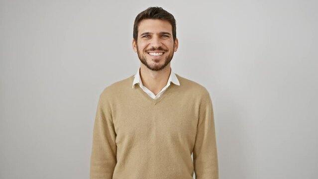 Young hispanic man wearing sweater standing looking positive and happy standing and smiling with a confident smile showing teeth over isolated white background