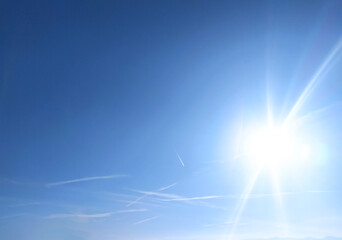 Clear blue sky texture and white fluffy cloud nature background. The sun shines bright in the...