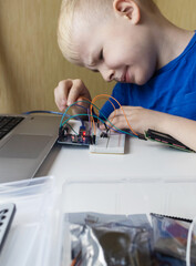 Programming for children. The boy is studying online at a robotics school for programming courses....
