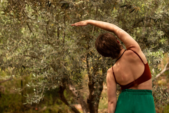 the girl makes side bends in nature, the girl is engaged in sports and somatic exercises in nature