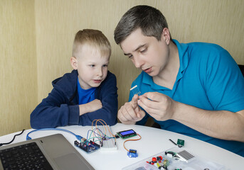 Programming for children. A teacher teaches a child at a robotics and IT school. Boy learning to...